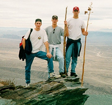 Three boys at the top of a cliff